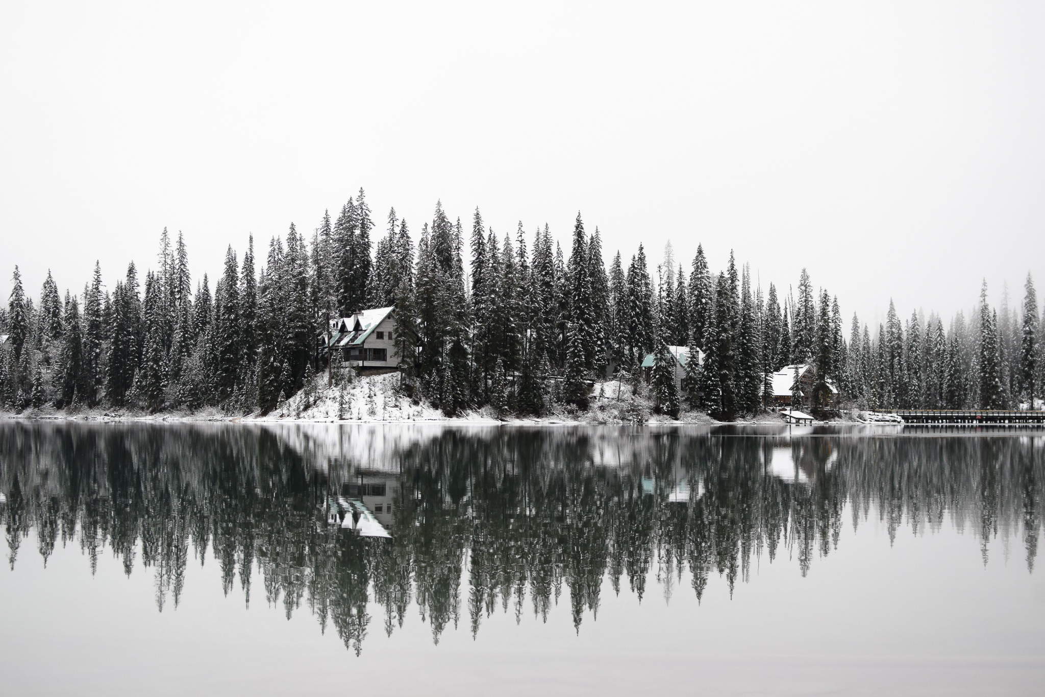 Gallery: snow-covered cabins reflected on a calm lake