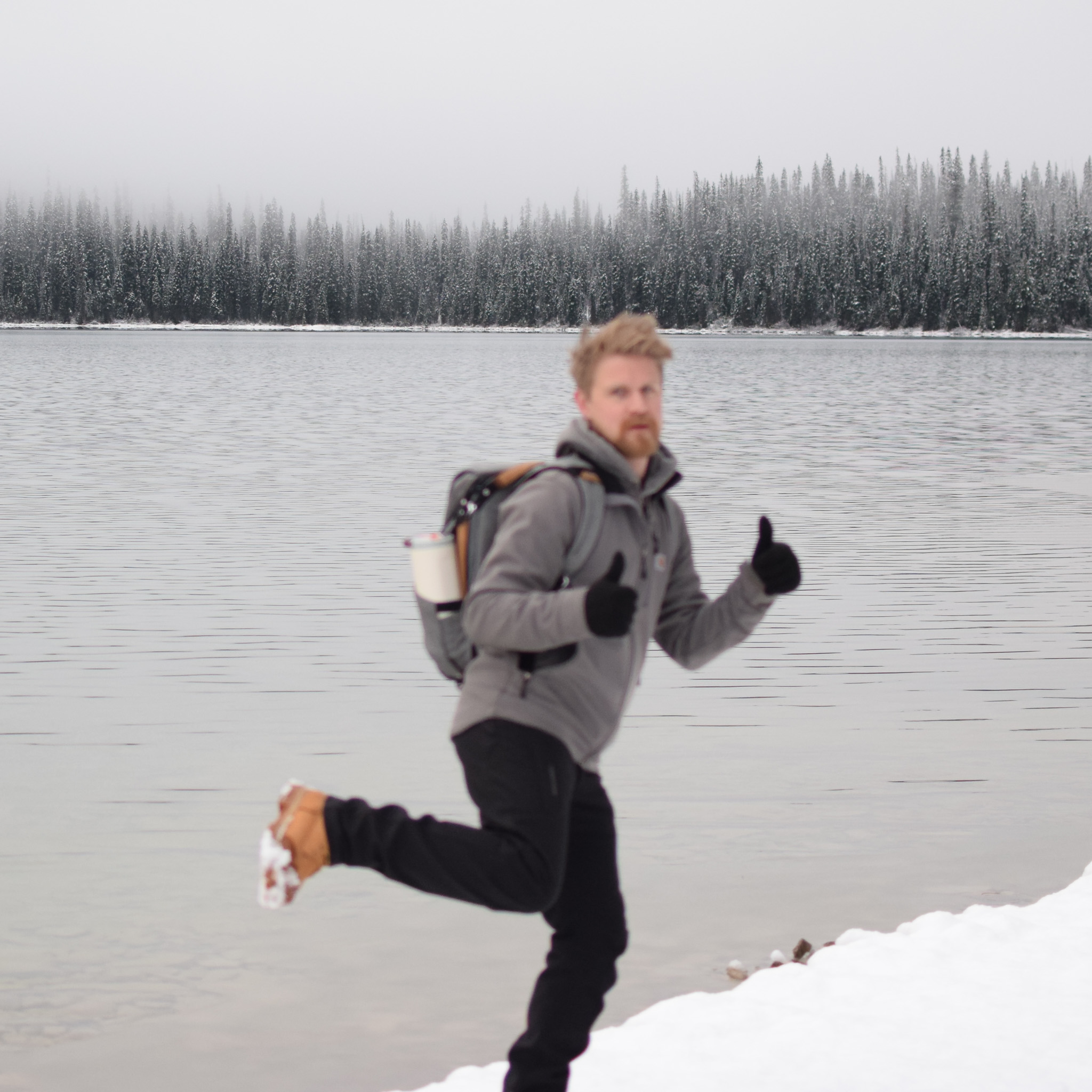 Lone figure running along a snowy lakeshore